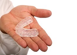 man holding mouthguard in hand