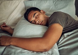 Man sleeping in bed while hugging pillow