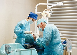Dental team carefully performing dental implant placement surgery