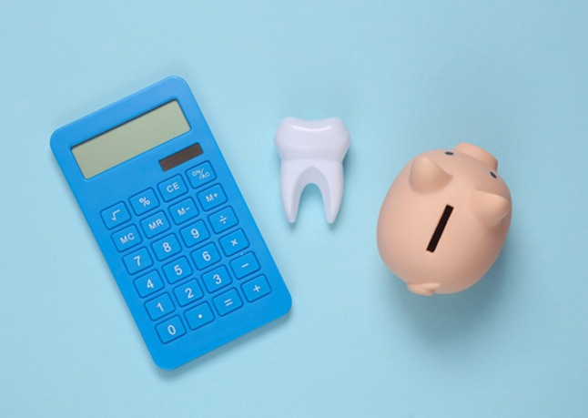 piggy bank and calculator and tooth for cost of cosmetic dentistry in Rome 