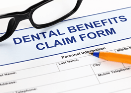 Close-up of dental benefits form with pen and glasses