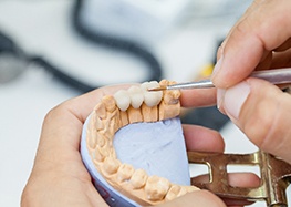 A lab technician working on dental crowns