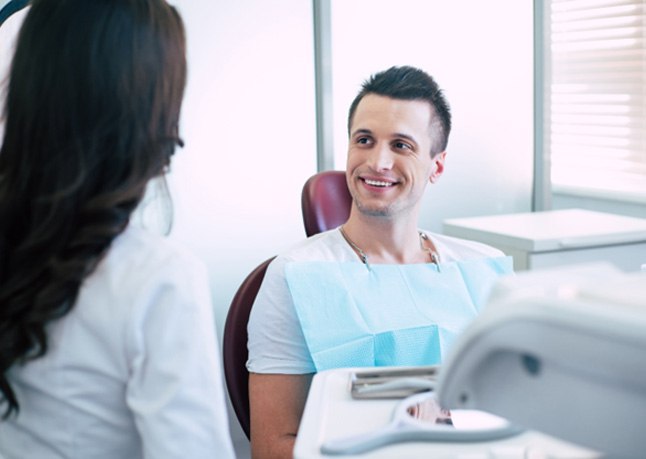 Patient smiling during appointment for scaling and root planing