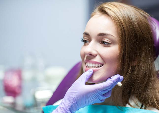 Young woman smiling after getting permanent dental crown 
