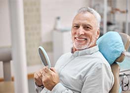 man smiling after getting dentures in Rome