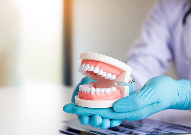 dentist holding dentures