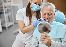 man smiling in dental mirror 