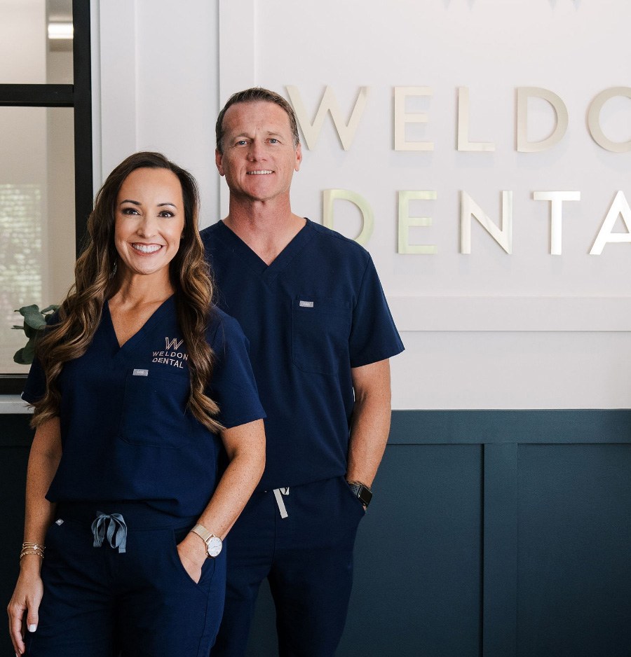 Doctors Ryan and Leigh Weldon smiling in dental office