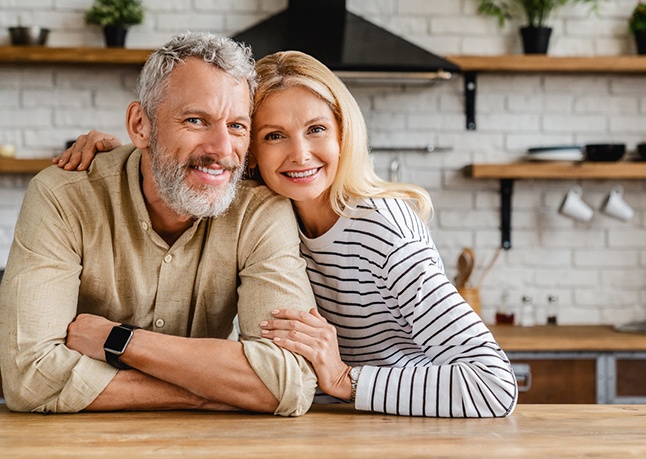 Older couple smiling inside their home