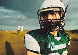 Teenager wearing football gear and mouthguard