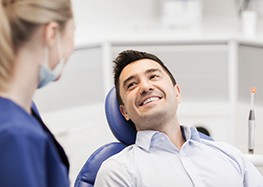 man smiling while getting dental implants in Rome