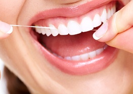 Woman flossing her dental implants in Rome