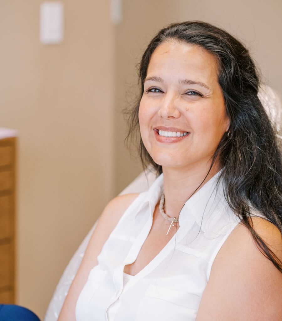 Smiling woman in sleeveless white blouse