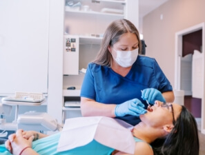 Dental team member giving a patient a teeth cleaning