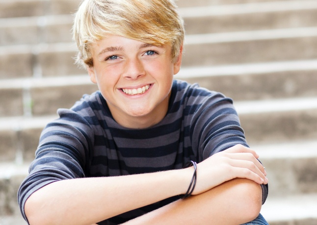 Teen boy smiling after dental sealant treatment