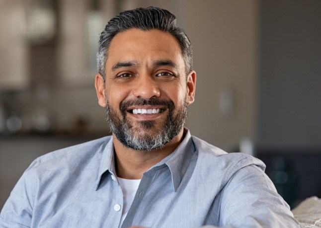 Man sharing flawless smile after full mouth reconstructions