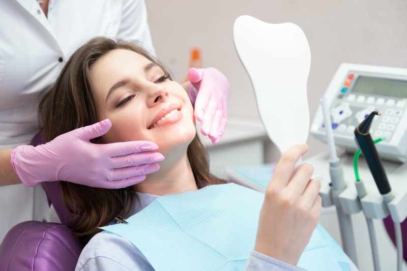 A young woman admiring the results of non-invasive cosmetic dentistry
