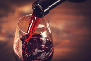 Pouring a glass of red wine.