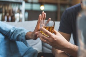 Person turning down glass of alcohol.
